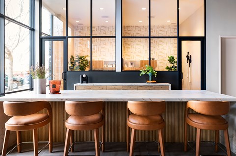 A modern kitchen with a long island and four chairs.
