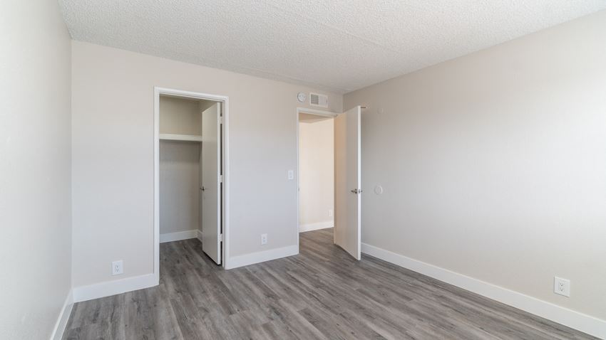 a bedroom with hardwood floors and white walls - Photo Gallery