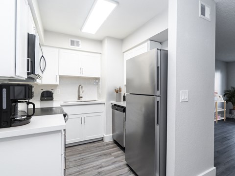 a kitchen with stainless steel appliances and white cabinets