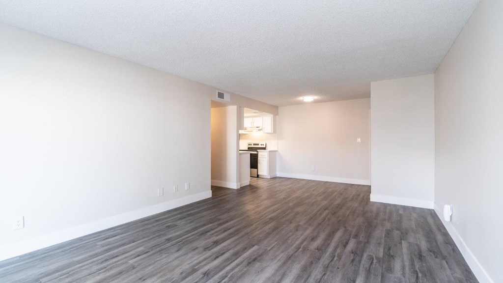 A room with wooden flooring and white walls.
