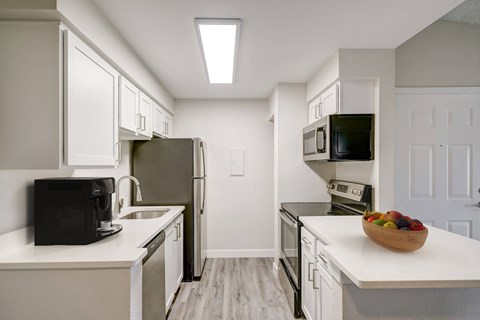 a renovated kitchen with white cabinets and stainless steel appliances