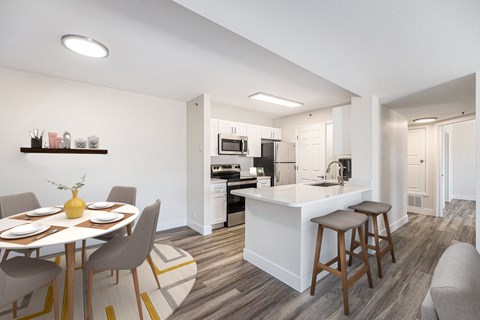 A modern kitchen with a dining table set for four.