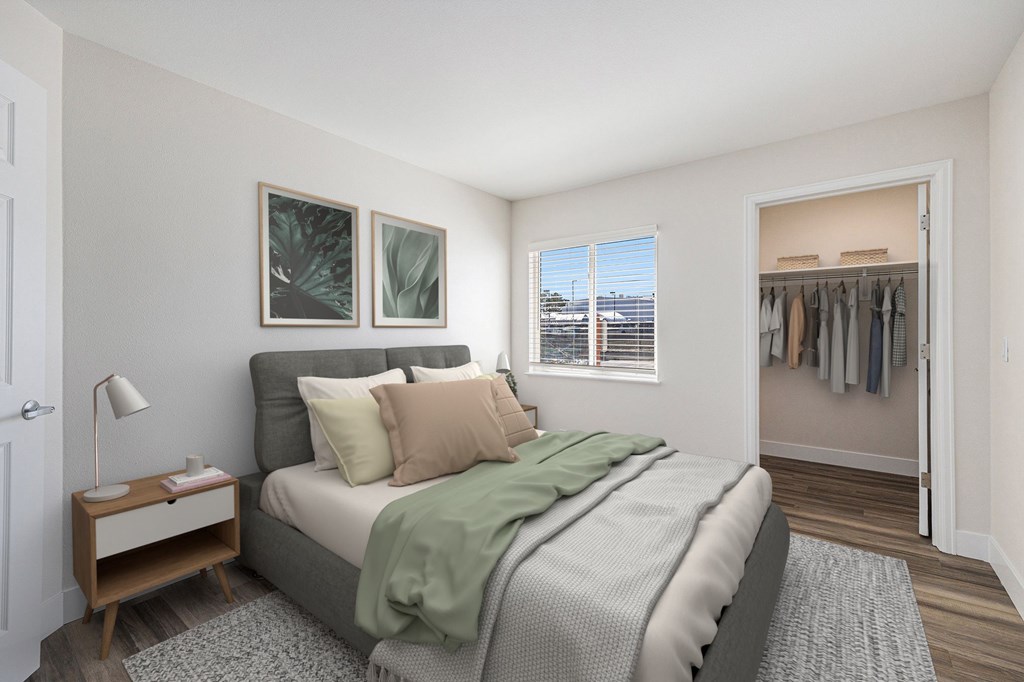 A bedroom with a bed, nightstand, and window.