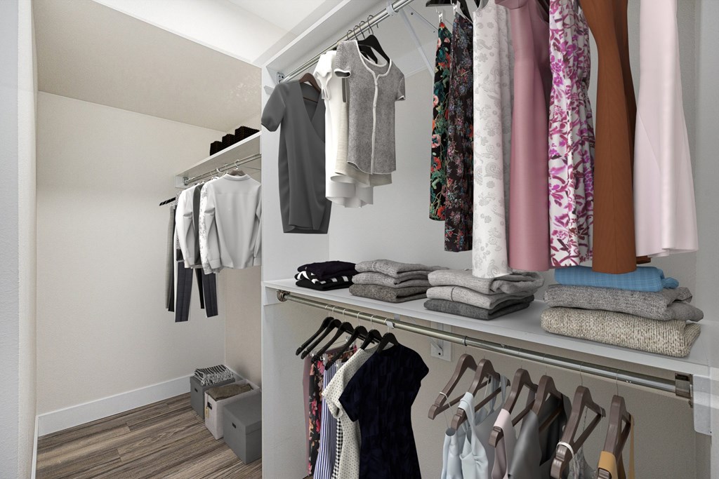 A closet with clothes hanging and folded on shelves.