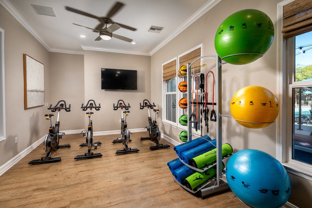 a home gym with exercise equipment and a ceiling fan