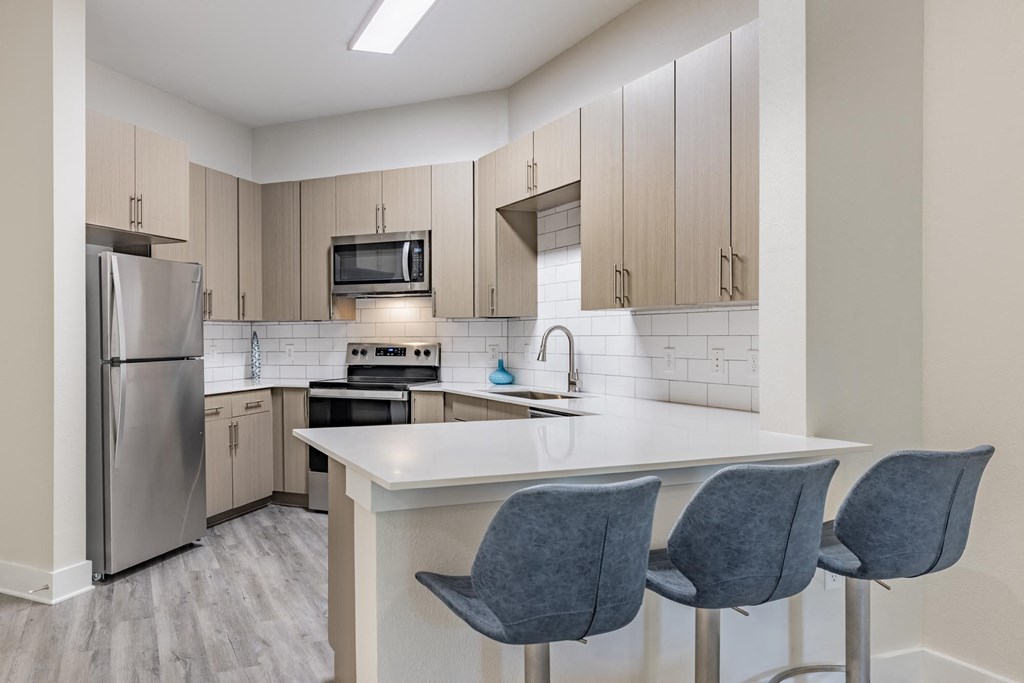 a kitchen with white countertops and gray cabinets