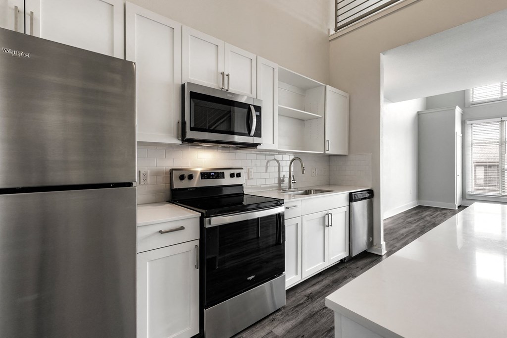 a kitchen with white cabinets and stainless steel appliances