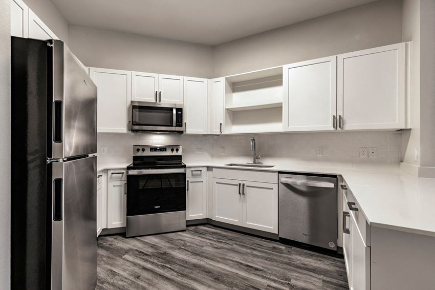 a kitchen with white cabinets and stainless steel appliances - Photo Gallery