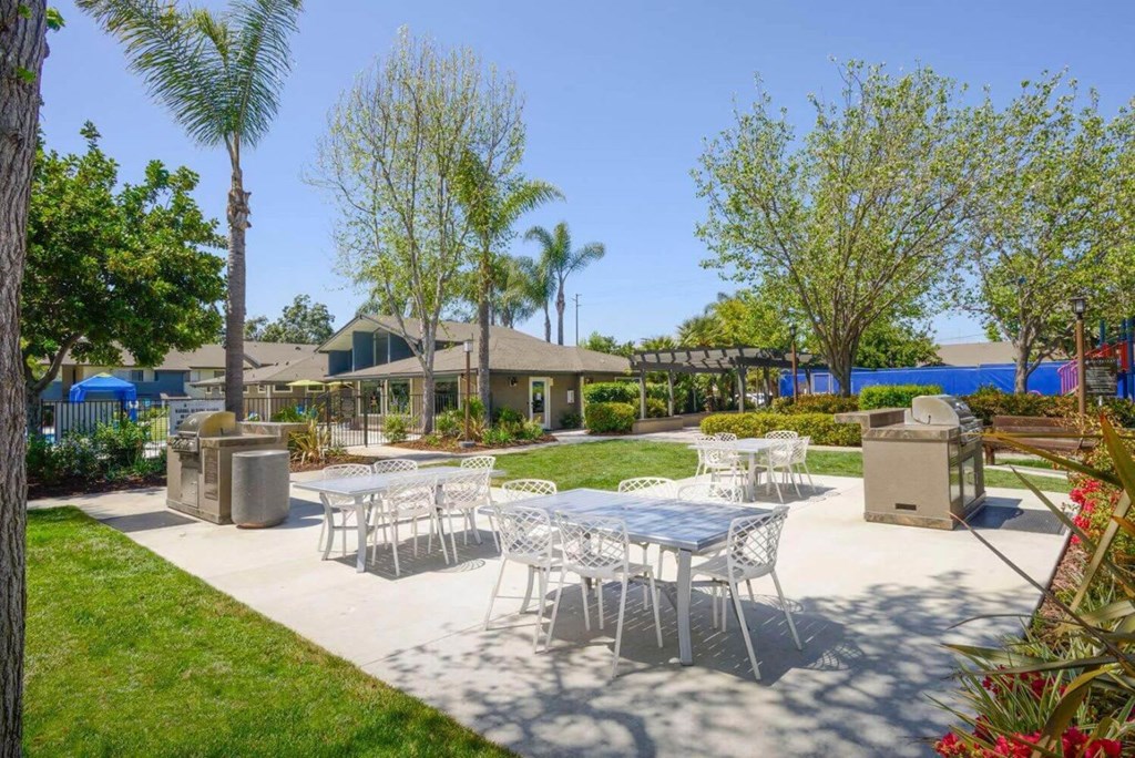 a patio with a table and chairs in front of a house
