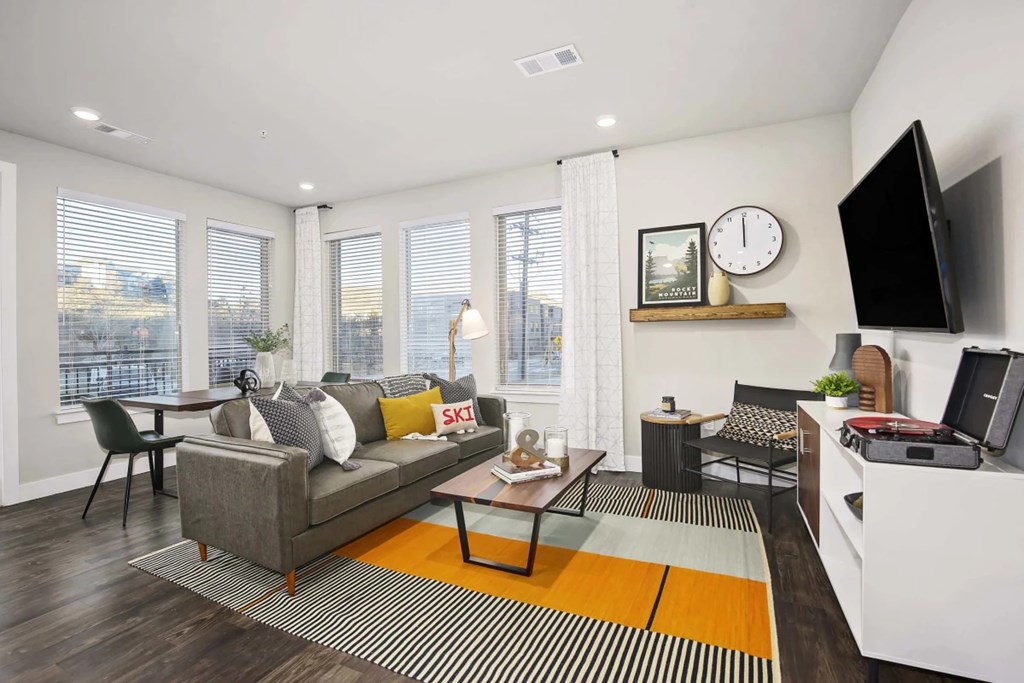 A living room with a grey couch, a coffee table, and a television.