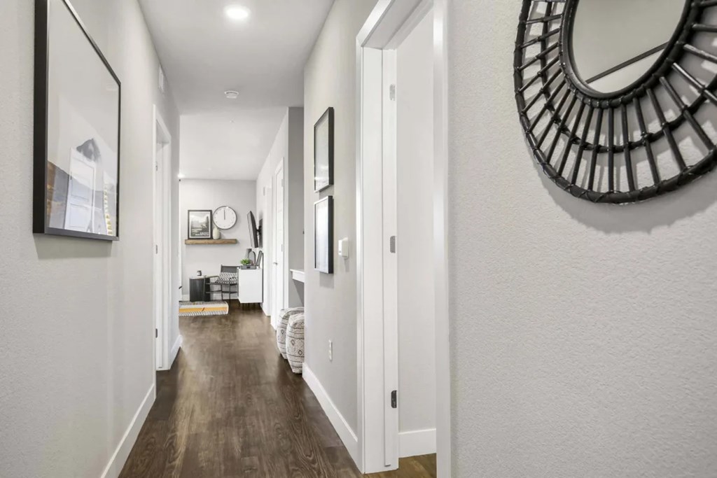 A long hallway with a mirror on the wall.