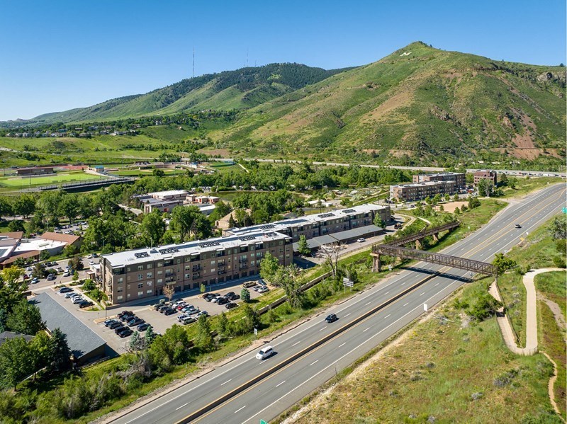A highway with cars driving on it and a mountain in the background.
