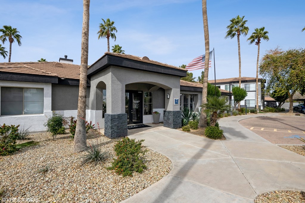 a building with palm trees and an flag in front of it