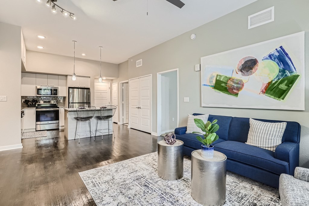 a living room with a blue couch and a white rug