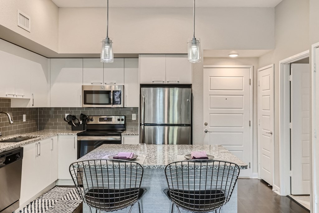 a kitchen with white cabinets and stainless steel appliances