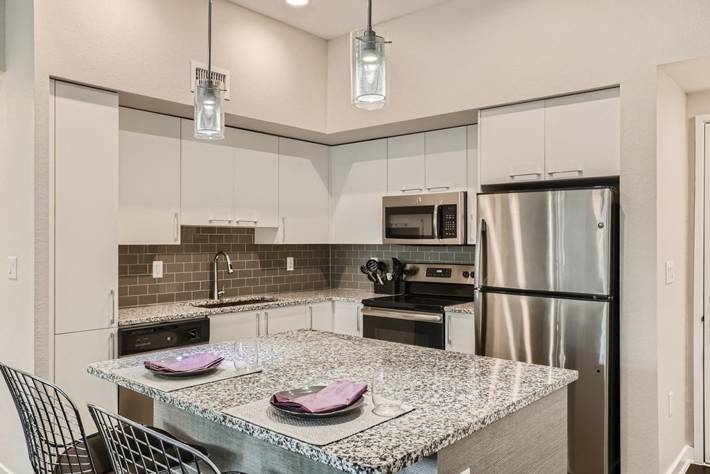 a kitchen with a large island and stainless steel appliances