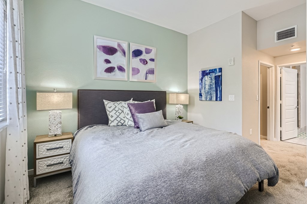 a bedroom with a large bed and two night stands with lamps