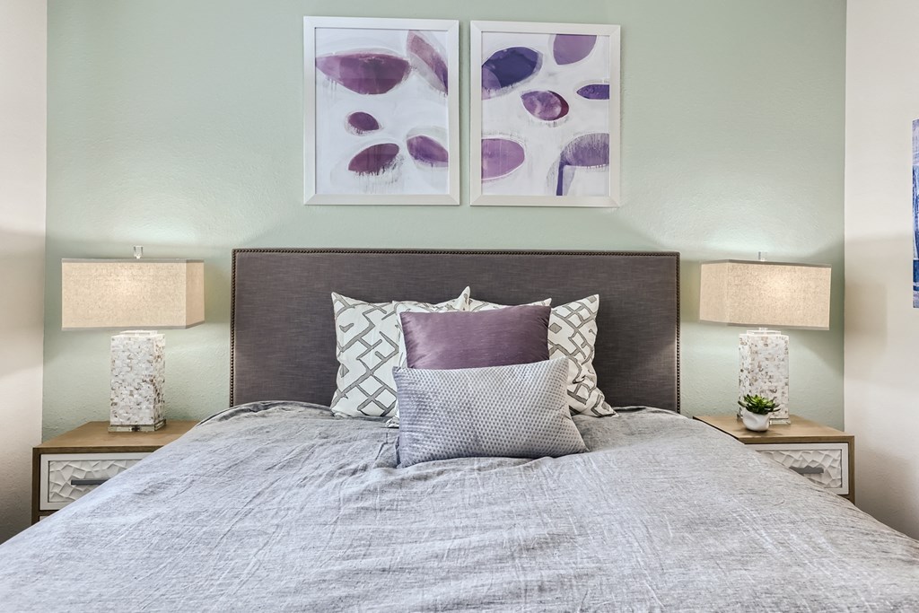 a bedroom with a bed and two night stands with lamps