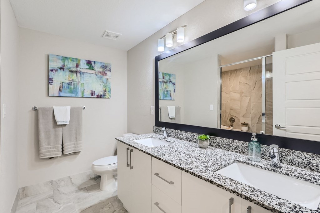 a bathroom with two sinks and a toilet