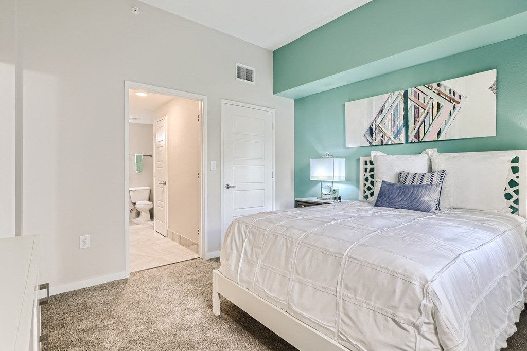 a bedroom with a bed and a door to a bathroom