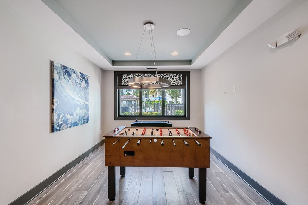 a game room with a pool table and a window