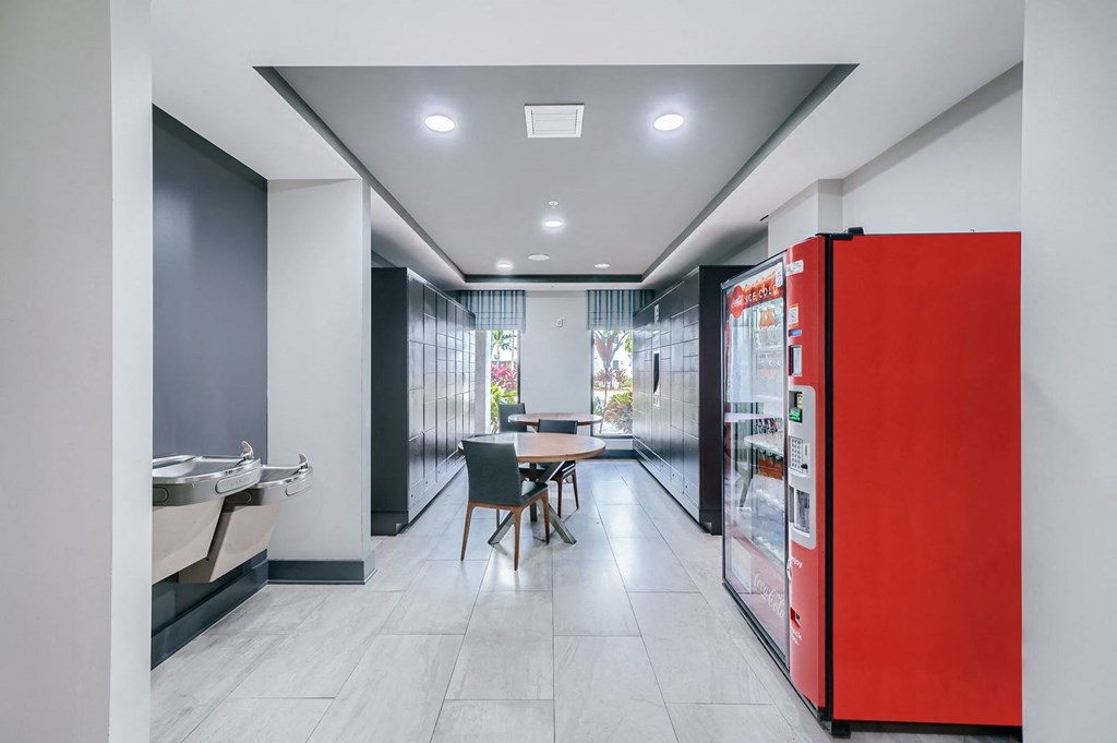 a room with a red refrigerator and a table and chairs
