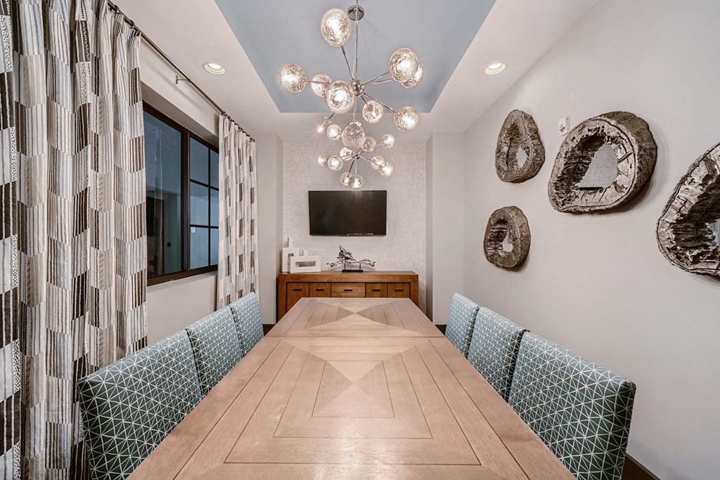 a dining room with a long wooden table and a chandelier