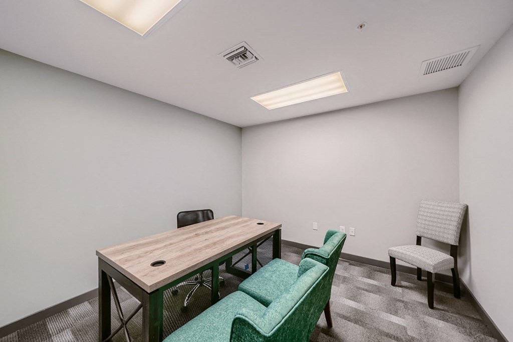a conference room with a wooden table and green chairs