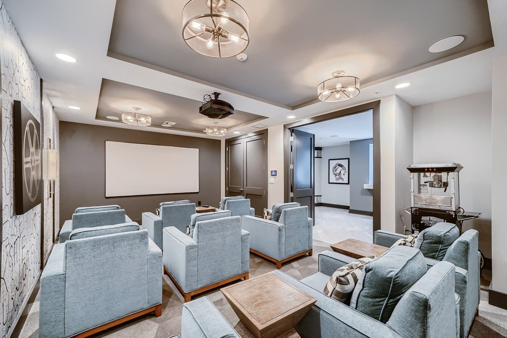 a large living room with couches and chairs and a projector screen