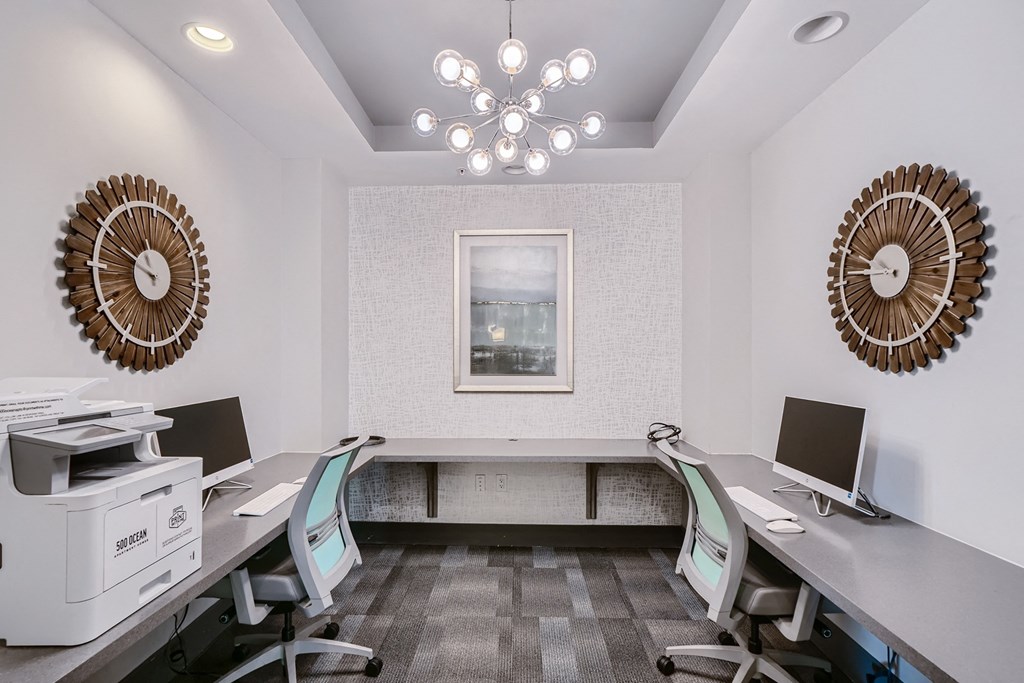a conference room with two desks and two computer monitors