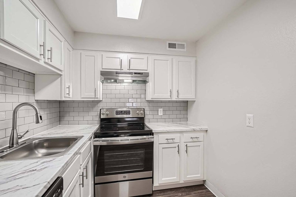 a kitchen with white cabinets and stainless steel appliances