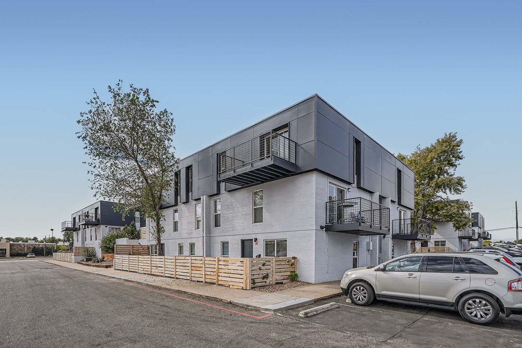 a new apartment building with a car parked in front of it