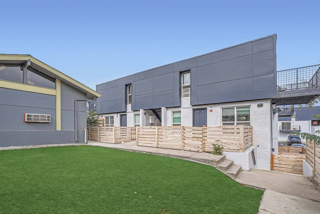 the backyard of a house with green grass and a patio