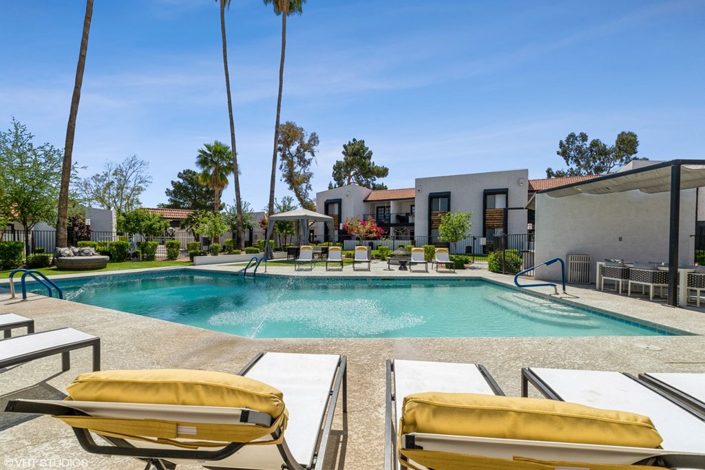 a swimming pool with lounge chairs and a gazebo