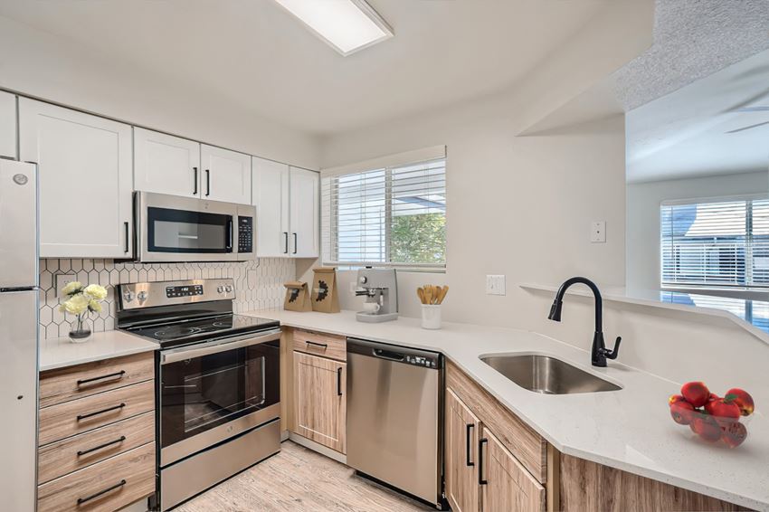 an updated kitchen with white cabinets and stainless steel appliances
