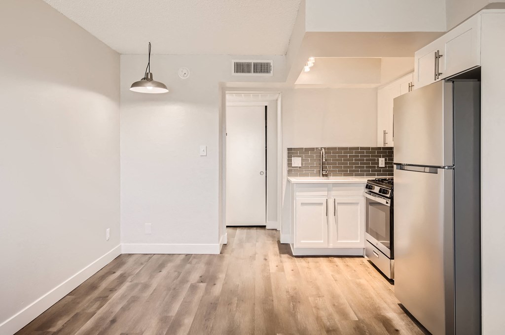 a kitchen with white cabinets and stainless steel appliances