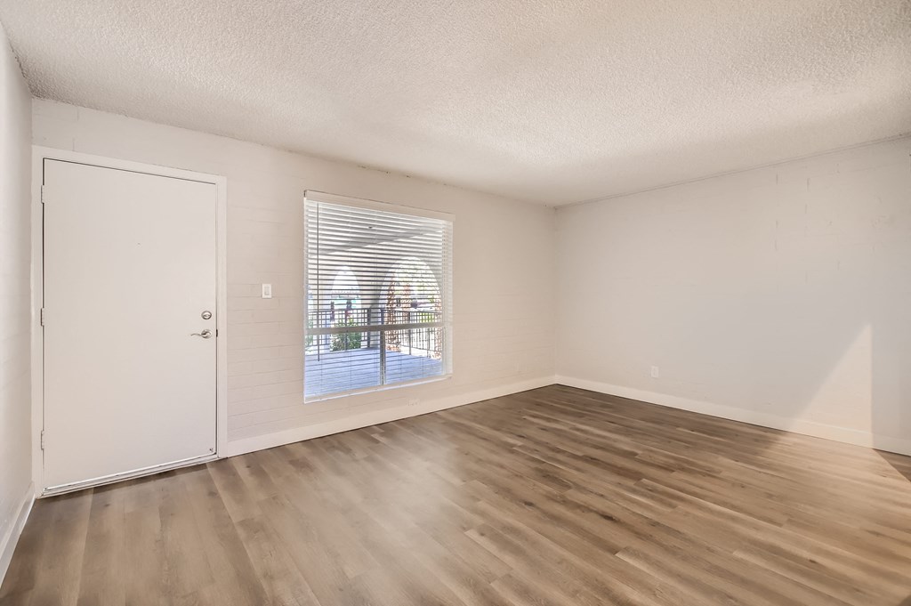 a bedroom with hardwood floors and a large window