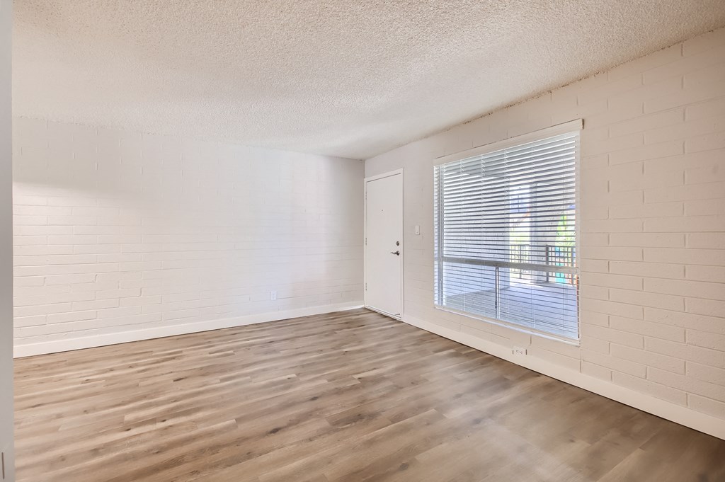 a bedroom with hardwood floors and a large window