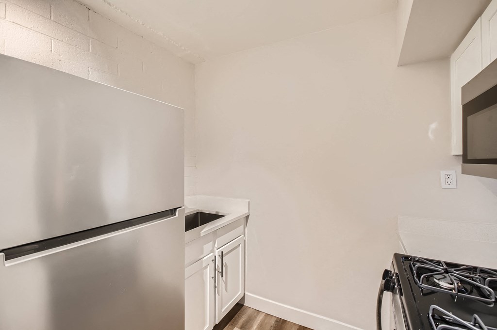 a kitchen with white cabinets and stainless steel appliances