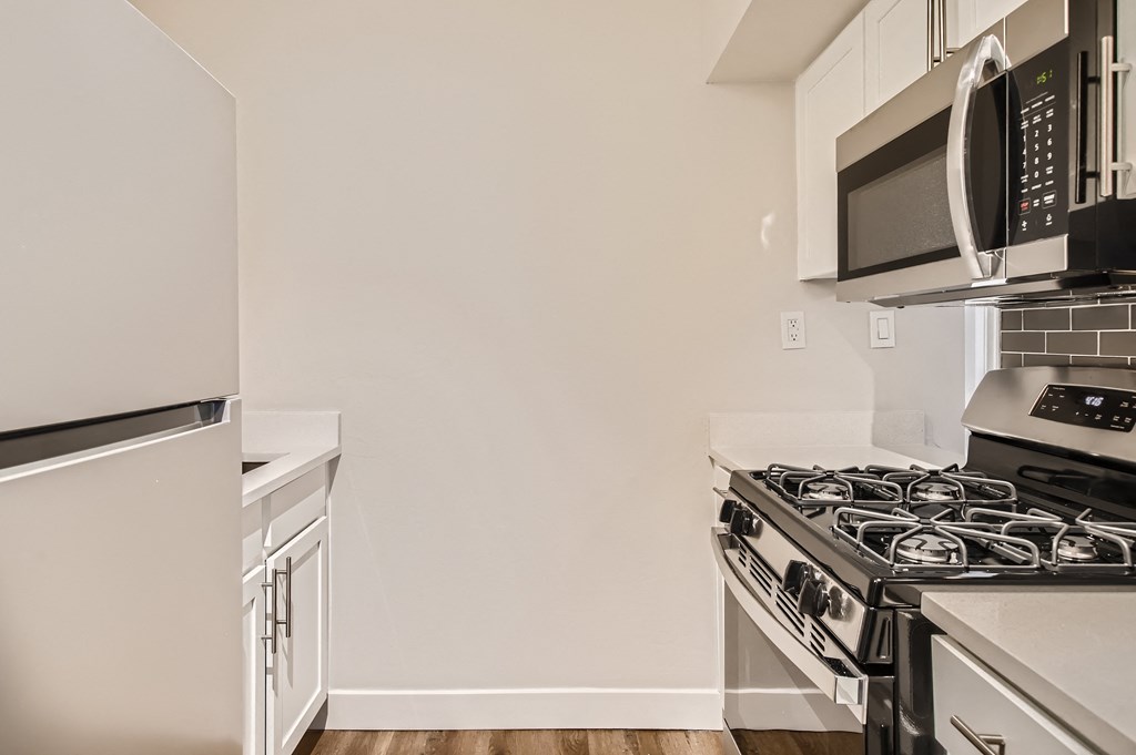 a kitchen with white cabinets and stainless steel appliances