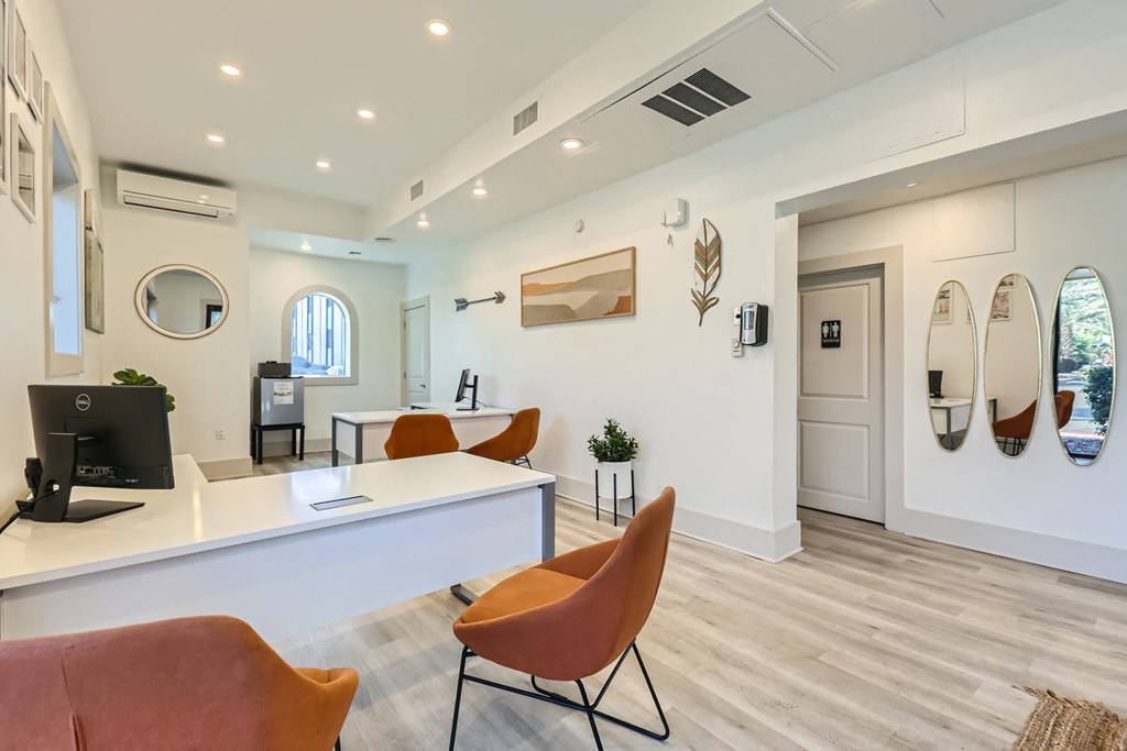 a reception area with chairs and a desk with a computer