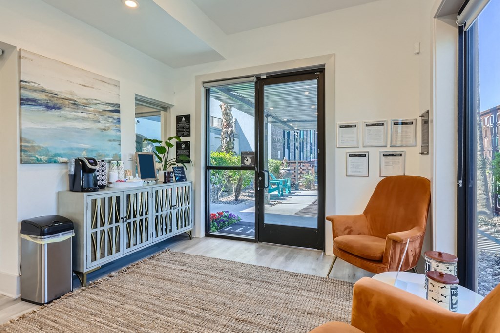 a living room with orange chairs and a door to a patio