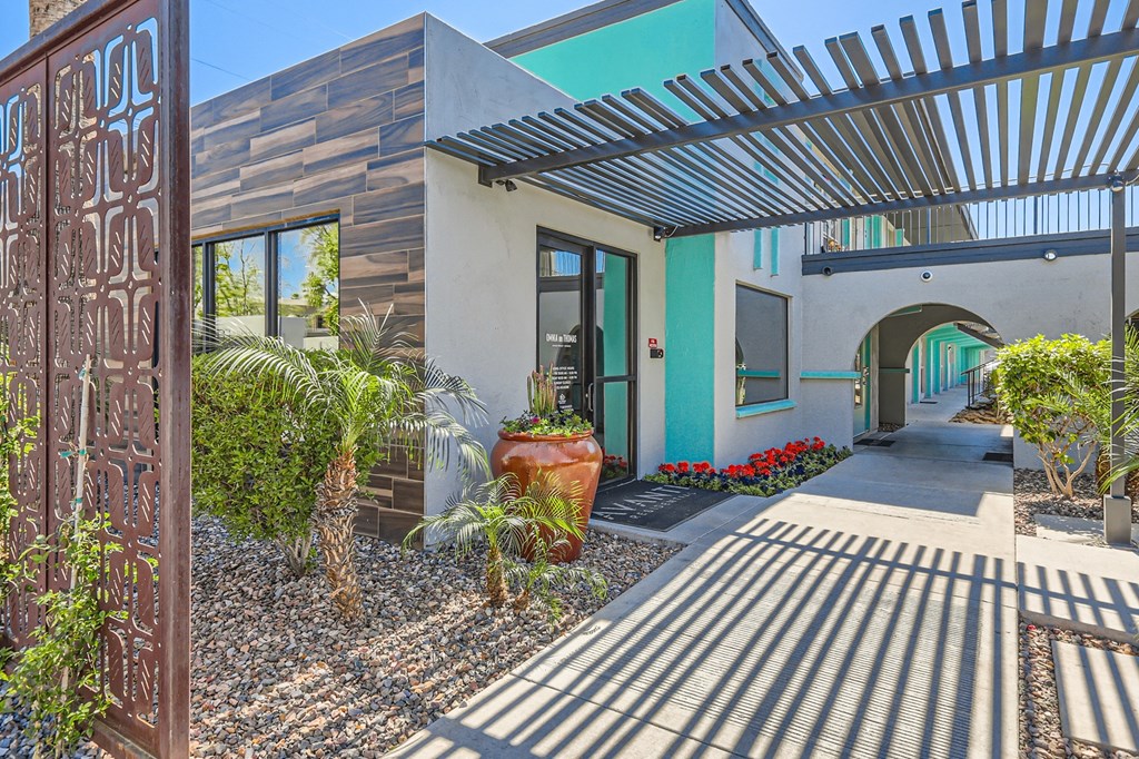 the entrance to a house with a sidewalk and plants