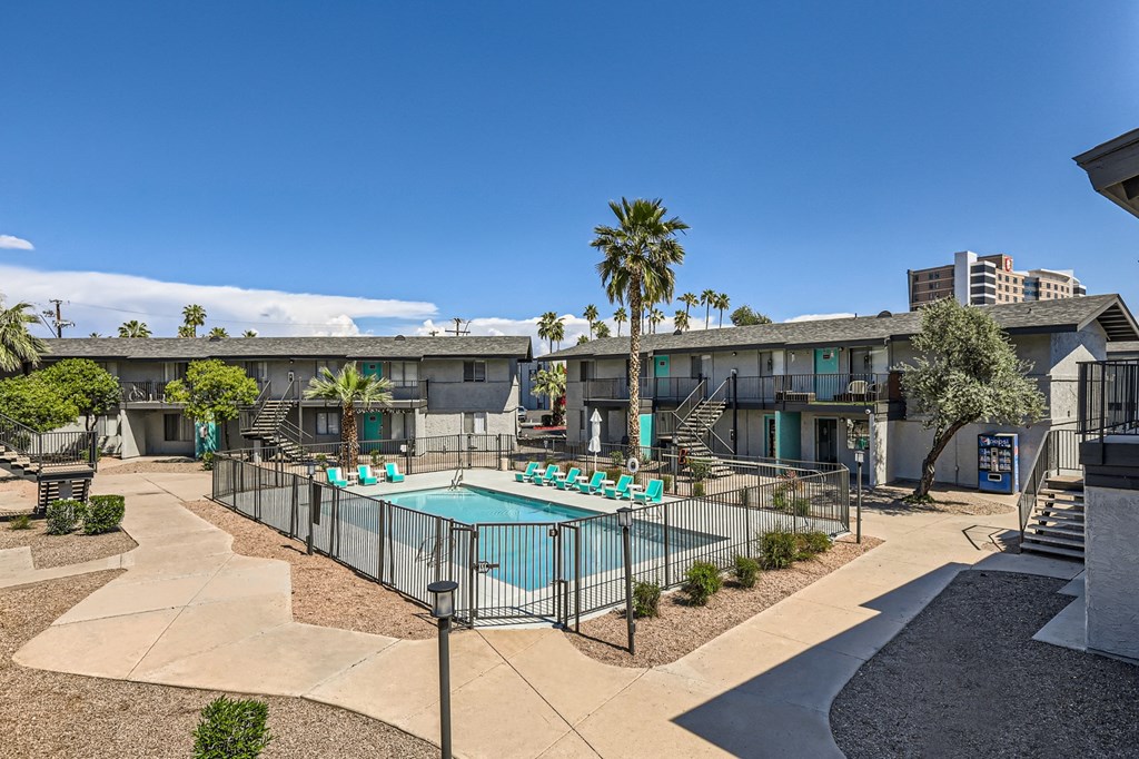 apartments with a pool and a building with palm trees