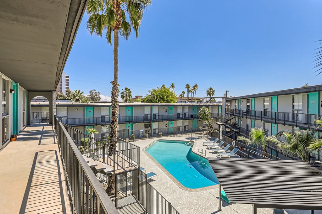 a view of a pool and a building with palm trees
