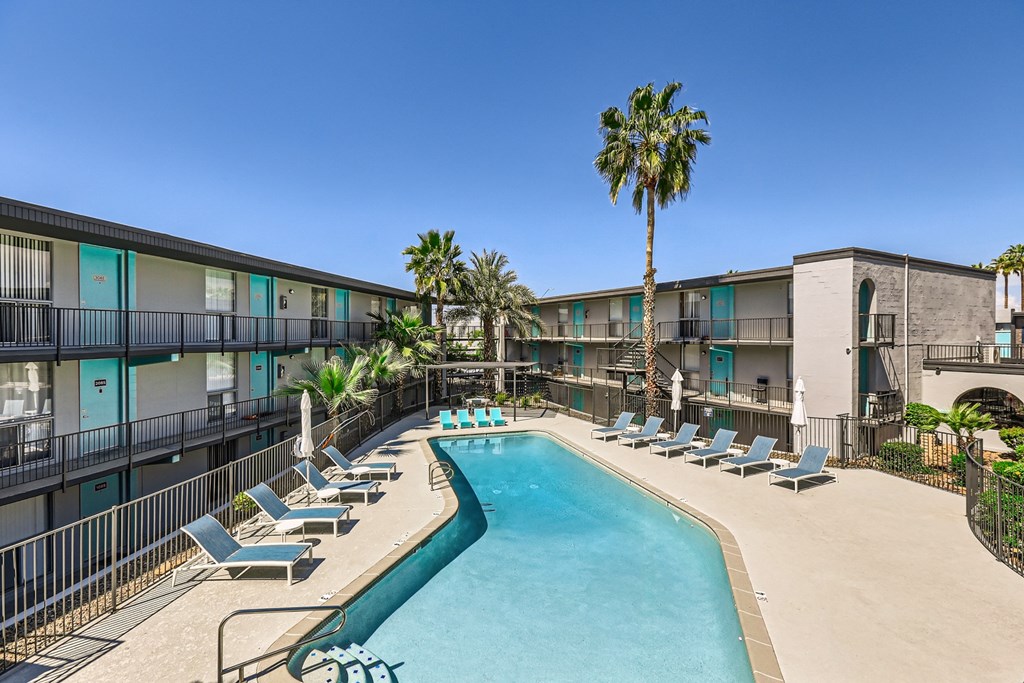 a resort style pool with lounge chairs and palm trees