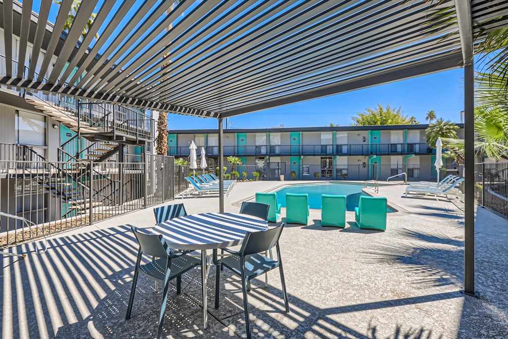a patio with a table and chairs and a swimming pool