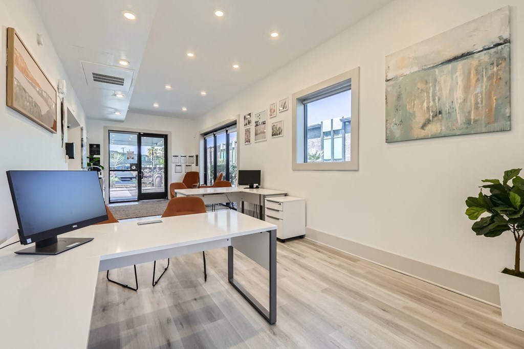 a white office with a desk and a computer