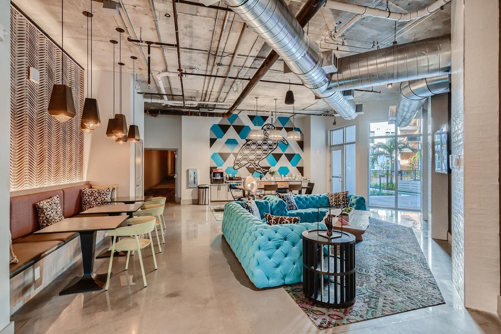 a lobby with a blue couch and tables and chairs