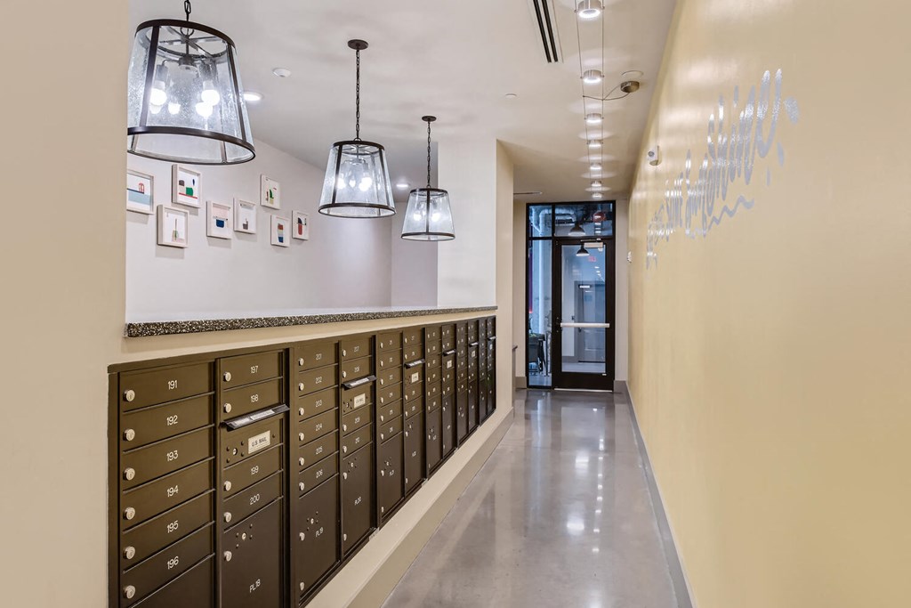 a long hallway with lockers and lights and a door